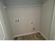 Laundry room featuring hookups, overhead wire shelving, and modern wood-look flooring at 3484 Enterkin Ln, Atlanta, GA 30349