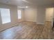 Bright, neutral living room featuring light wood flooring and two large windows at 3484 Enterkin Ln, Atlanta, GA 30349