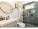 Stylish bathroom featuring modern vanity, round mirror, and glass enclosed shower with gray subway tiles at 299 Fletcher Sw St, Atlanta, GA 30315