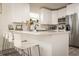 Bright kitchen boasts white cabinetry, granite countertops and stainless steel appliances for modern living at 299 Fletcher Sw St, Atlanta, GA 30315