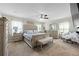 Bright bedroom features large bed with tufted headboard, neutral carpet, and lots of furniture at 450 Noblewood Dr, Mcdonough, GA 30252