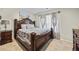 Traditional bedroom with decorative wood bed frame, neutral carpet, and natural light at 450 Noblewood Dr, Mcdonough, GA 30252
