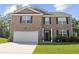Charming two-story brick home featuring a two-car garage, dark shutters, and a well-manicured lawn at 450 Noblewood Dr, Mcdonough, GA 30252