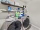Laundry room with front load washer and dryer and open shelving at 450 Noblewood Dr, Mcdonough, GA 30252