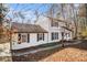 A lovely home with white siding, black shutters, and a charming walkway surrounded by mature trees at 7935 Sweetwater Dr, Douglasville, GA 30135