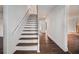 Bright interior shot showcasing a staircase with wooden steps and white risers, adjacent to hardwood floors at 7935 Sweetwater Dr, Douglasville, GA 30135