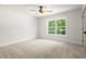 This bedroom has neutral carpet, walls and trim with a big window at 5125 Hyde Trl, Cumming, GA 30040