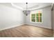 Dining room with hardwood floors, trey ceiling, modern chandelier, and a large window at 5125 Hyde Trl, Cumming, GA 30040