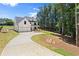 Front exterior view of a home with an attached garage, a long driveway, and mature trees at 5125 Hyde Trl, Cumming, GA 30040