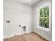 A bright laundry room with laminate floors, hookups, and wire shelves at 5125 Hyde Trl, Cumming, GA 30040