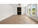 A bright living room features a modern fireplace, large windows, and light wood floors at 5125 Hyde Trl, Cumming, GA 30040