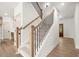 Bright staircase featuring light wood railings and black metal balusters, leading to the upper level at 5125 Hyde Trl, Cumming, GA 30040