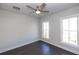A bright bedroom has hardwood floors, a ceiling fan, and large windows that offer views of the neighborhood at 280 Briscoe Way # 38, Alpharetta, GA 30009