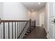 Upstairs hallway with dark hardwood floors, iron railing and a view through an open doorway at 280 Briscoe Way # 38, Alpharetta, GA 30009