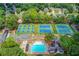 Aerial view featuring community pool and tennis courts surrounded by lush greenery and neighborhood homes at 1446 Chadwick Ridge Ct, Lawrenceville, GA 30043