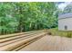 Wooden back deck features a built-in bench and a grill area, providing a scenic view of the surrounding trees at 1446 Chadwick Ridge Ct, Lawrenceville, GA 30043