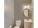 Charming half-bathroom with striped wallpaper, pedestal sink, and decorative mirror at 1446 Chadwick Ridge Ct, Lawrenceville, GA 30043
