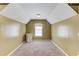 An angled room with a neutral carpet and a white mini-fridge and a window at 1446 Chadwick Ridge Ct, Lawrenceville, GA 30043