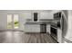 Well-lit modern kitchen features white cabinets, stainless appliances, and view to the outdoor patio at 198 Colbury St, Villa Rica, GA 30180
