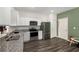 Well-lit kitchen with stainless steel appliances, granite countertops, and dark wood-look flooring at 198 Colbury St, Villa Rica, GA 30180