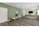 Large open living space with green accent wall and wood floors; access to the kitchen and dining areas at 198 Colbury St, Villa Rica, GA 30180