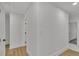 Bright hallway featuring light wood floors and crisp white walls, leading to other areas of the house at 2358 Tilson Rd, Decatur, GA 30032
