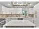 Modern kitchen featuring white cabinets, a large island, and stunning backsplash at 2358 Tilson Rd, Decatur, GA 30032