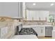 Close up of a modern kitchen featuring a gas range, quartz countertops, and sleek hardware at 2358 Tilson Rd, Decatur, GA 30032