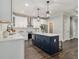 Well-appointed kitchen showcasing a navy island with white countertops and pendant lighting at 490 Third Ave, Scottdale, GA 30079