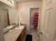 Bathroom featuring a single sink vanity, and a shower with a red patterned curtain at 15 Emerson Trl, Covington, GA 30016
