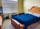 This bedroom has a wooden bed frame, neutral carpet, and blinds on the windows at 15 Emerson Trl, Covington, GA 30016