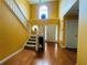 Bright foyer featuring hardwood floors, a staircase, and a view of the front door at 15 Emerson Trl, Covington, GA 30016