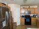 Functional kitchen with stainless steel refrigerator, wood cabinets, and modern appliances at 15 Emerson Trl, Covington, GA 30016