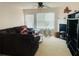 Cozy living room with a plush sofa, fireplace, and natural light streaming through the window at 15 Emerson Trl, Covington, GA 30016