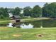 Scenic view of a pond with a gazebo, lush trees, and grassy shoreline at 15 Emerson Trl, Covington, GA 30016