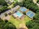 Aerial view of community pool, playground, parking and tennis courts surrounded by trees at 1539 School House Run, Dacula, GA 30019