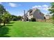 Lush, green backyard showcasing a well-manicured lawn, the home's exterior, and a charming deck at 1539 School House Run, Dacula, GA 30019