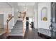Welcoming foyer with hardwood floors, staircase, and view into the living room with fireplace at 1539 School House Run, Dacula, GA 30019