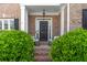 Inviting front porch with brick columns, rocking chairs, and stylish black front door at 1539 School House Run, Dacula, GA 30019