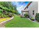 Expansive backyard featuring lush lawn, mature trees, and a charming garden area at 1530 Parkside Village Dr, Cumming, GA 30040