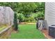 Well-maintained backyard with lush greenery, a wooden fence, and access gate at 1530 Parkside Village Dr, Cumming, GA 30040