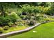 Lush backyard with terraced garden, mature trees and vibrant ground cover at 1530 Parkside Village Dr, Cumming, GA 30040