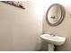 Elegant powder room showcasing a pedestal sink, a round mirror, and decorative wall art for a refined touch at 1530 Parkside Village Dr, Cumming, GA 30040