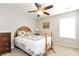 Cozy bedroom with a wooden headboard, ceiling fan, and natural light from the window at 1530 Parkside Village Dr, Cumming, GA 30040