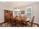 Formal dining room with hardwood floors, elegant lighting, wainscoting, and a large dining table at 1530 Parkside Village Dr, Cumming, GA 30040