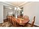 Dining room with wainscoting, chandelier lighting, and doorway access to the stairs and foyer at 1530 Parkside Village Dr, Cumming, GA 30040