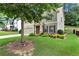 Charming two-story home with a well-manicured lawn, mature trees, and inviting curb appeal at 1530 Parkside Village Dr, Cumming, GA 30040