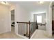 Upstairs hallway with carpet, wood railing staircase, and natural light provides seamless transition between rooms at 1530 Parkside Village Dr, Cumming, GA 30040