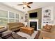 Comfortable living room with fireplace, built-in shelving, and ceiling fan at 1530 Parkside Village Dr, Cumming, GA 30040