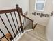 Carpeted staircase with dark wood railing leads to upper level, accented with decorative photos along the wall at 1530 Parkside Village Dr, Cumming, GA 30040